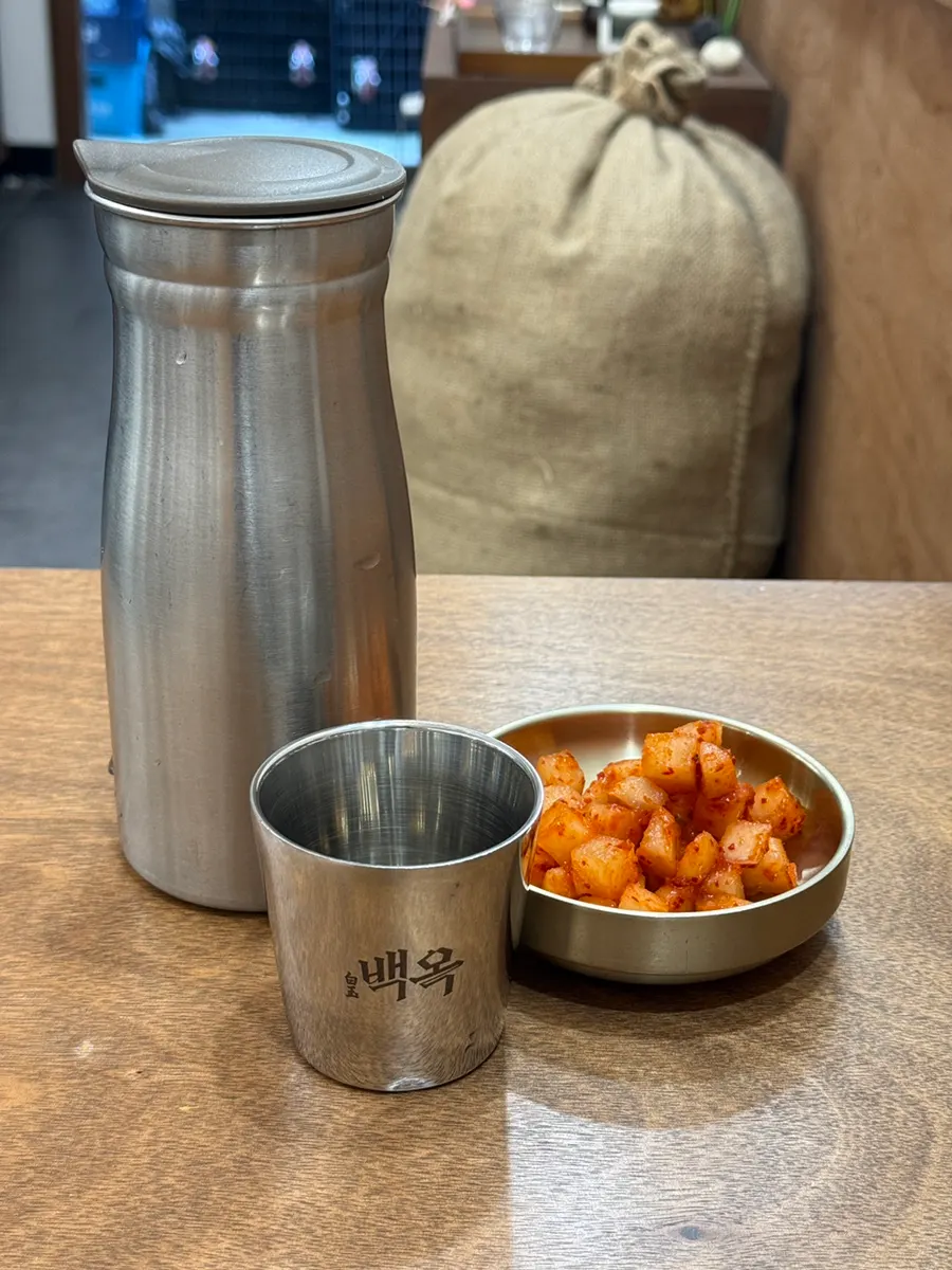Water cup printed with the restaurant name, alongside kkakdugi