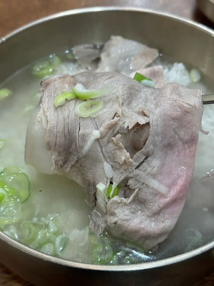 A spoonful of pork gomtang with rice mixed into the broth