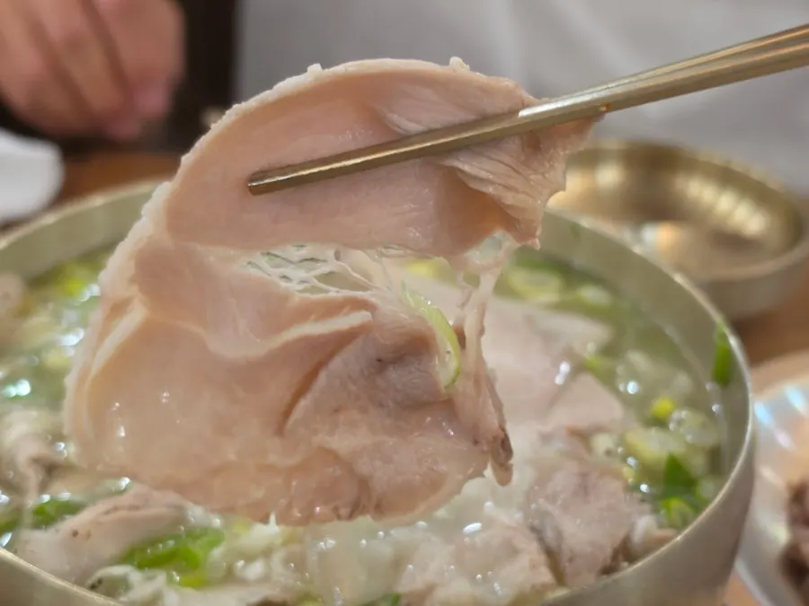 Lifting a piece of pork from the gomtang