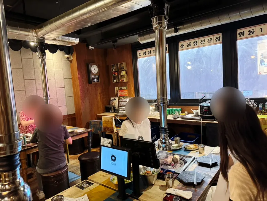 Dining hall lined with four-top tables at Yuktongnyeong Myeongdong Main Branch