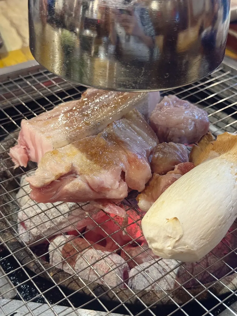 Staff member grilling the black pork