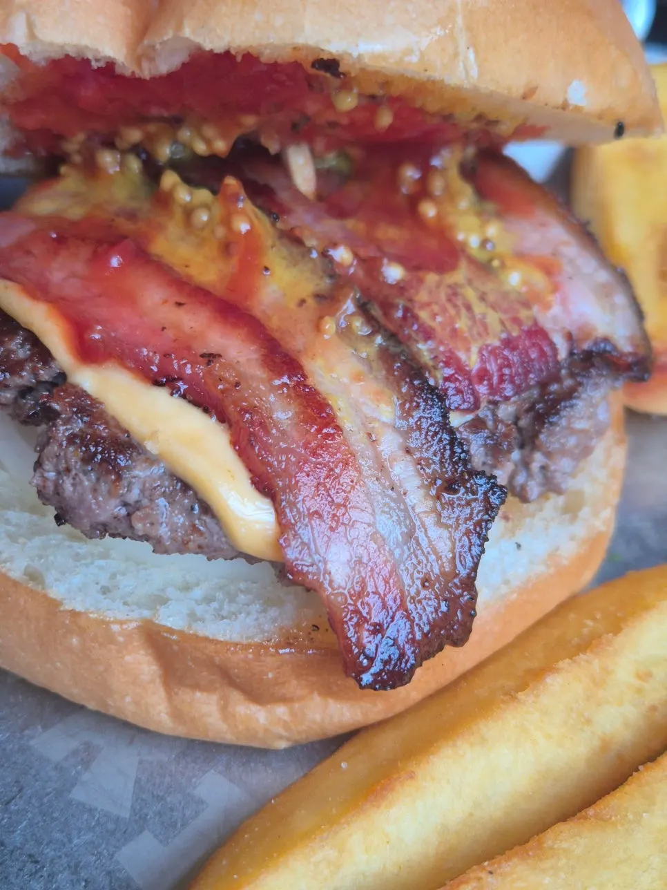 A bite taken out of the bacon cheeseburger