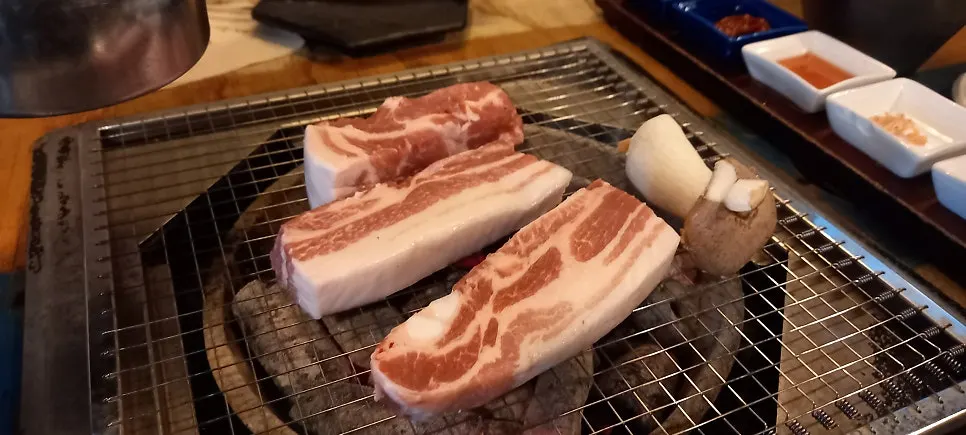 노릇하게 익은 고기가 놓인 숯불 불판