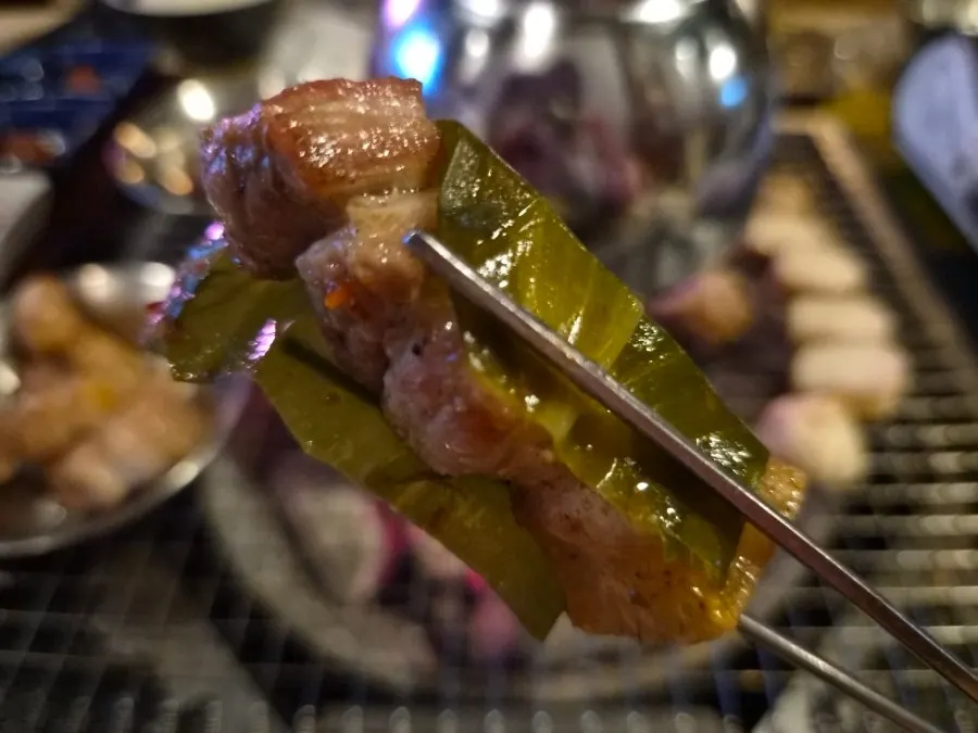 파채와 절임 채소를 올린 오겹살 한 점