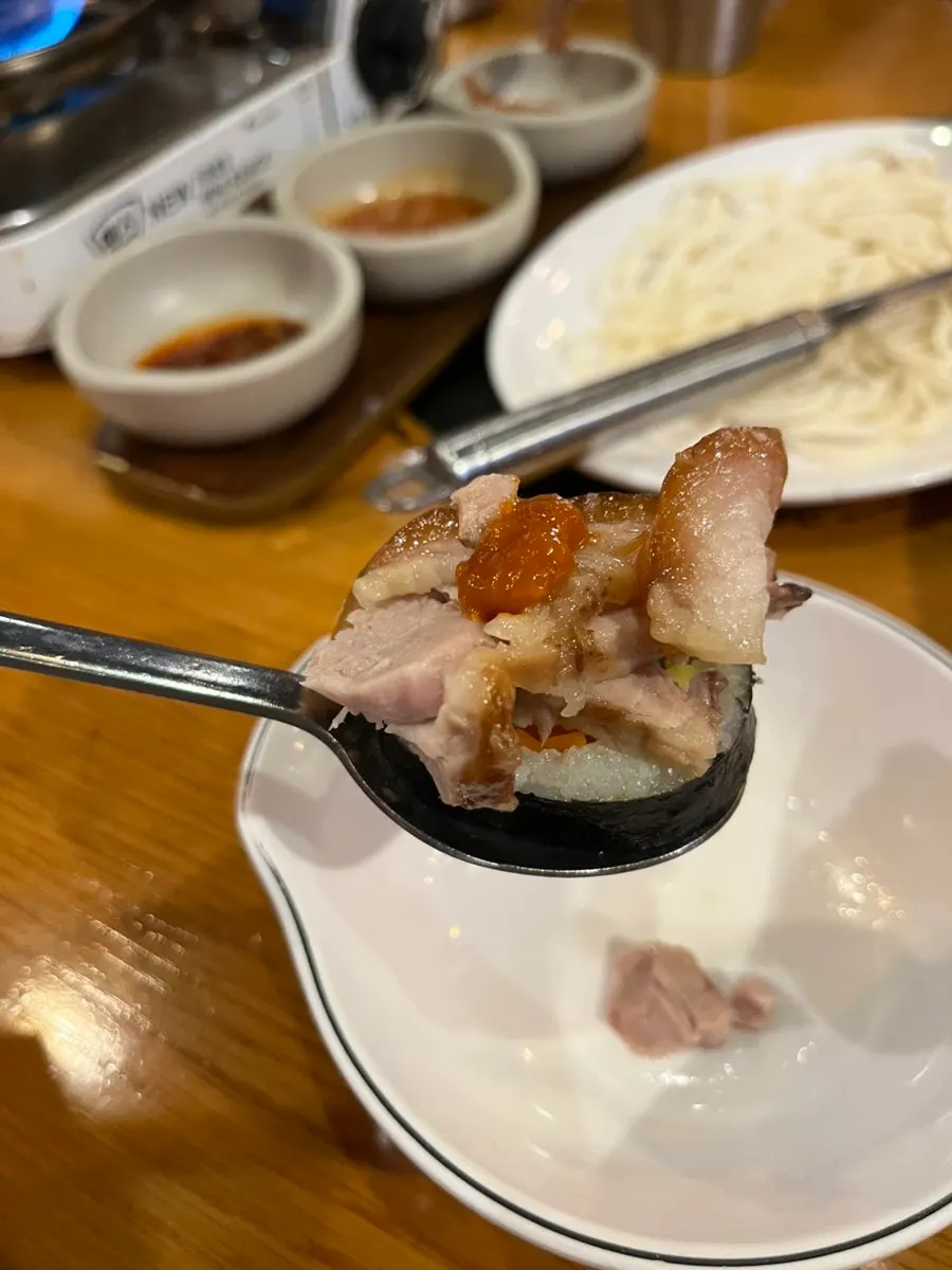 A piece of jokbal with ssamjang and garlic