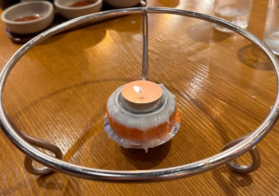 Basic table setting with a candle for keeping jokbal warm