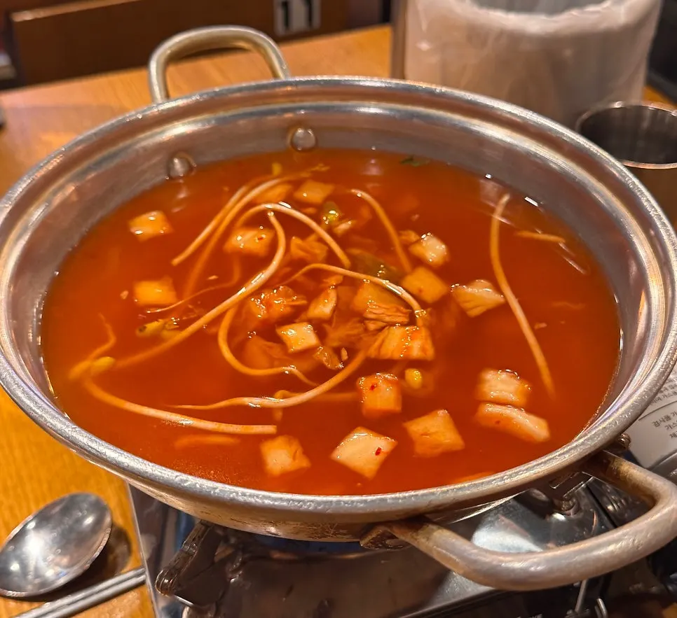 Kimchi bean sprout soup boiling with kalguksu noodles added