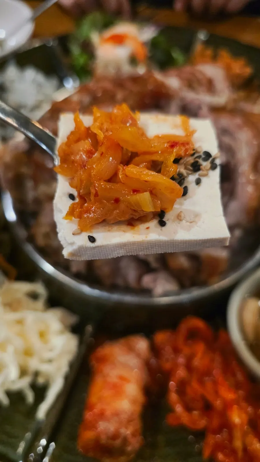 두부김치를 집어 먹는 모습