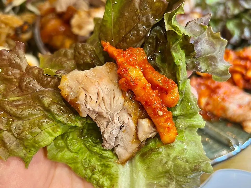 Lettuce wrap topped with meat and bossam radish salad