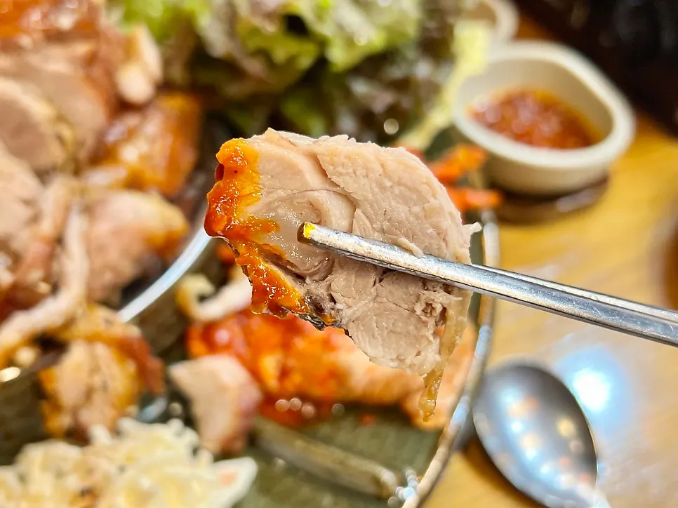 A piece of jokbal dipped in mala sauce
