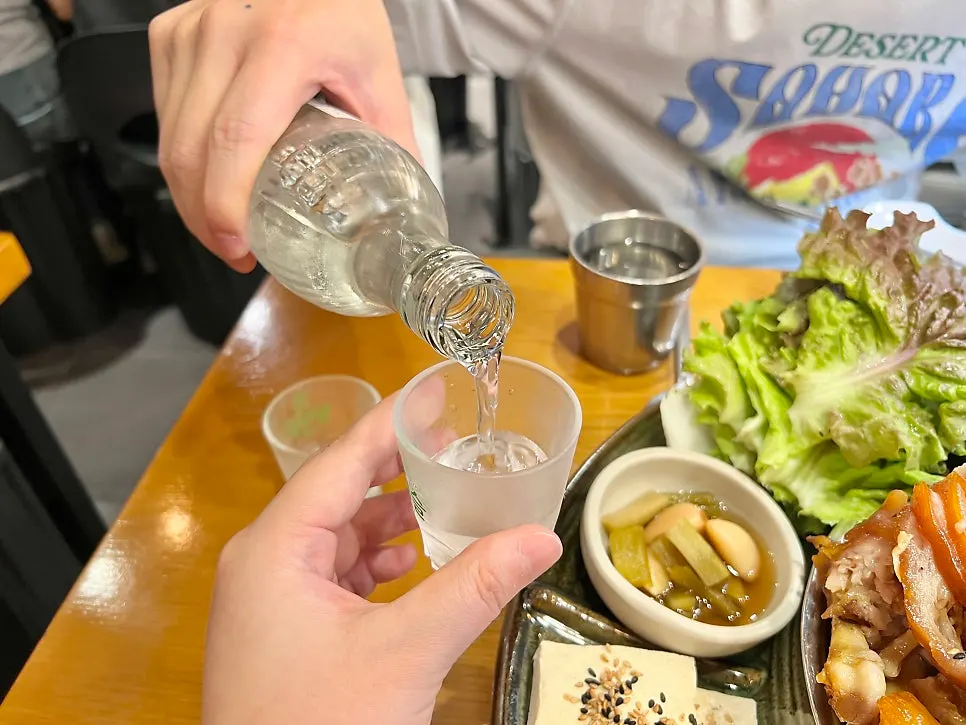 Table with jokbal and an empty soju bottle