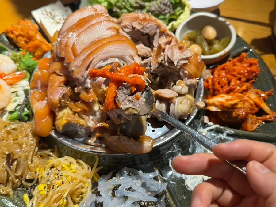 Jokbal dipped into the mala sauce