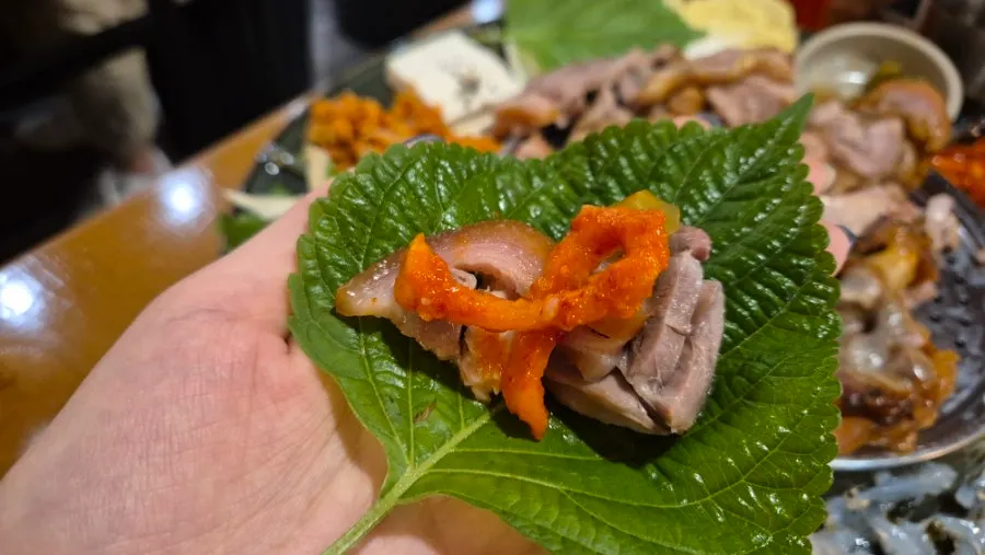 Perilla leaf wrap with jokbal, pickled radish, and raw garlic