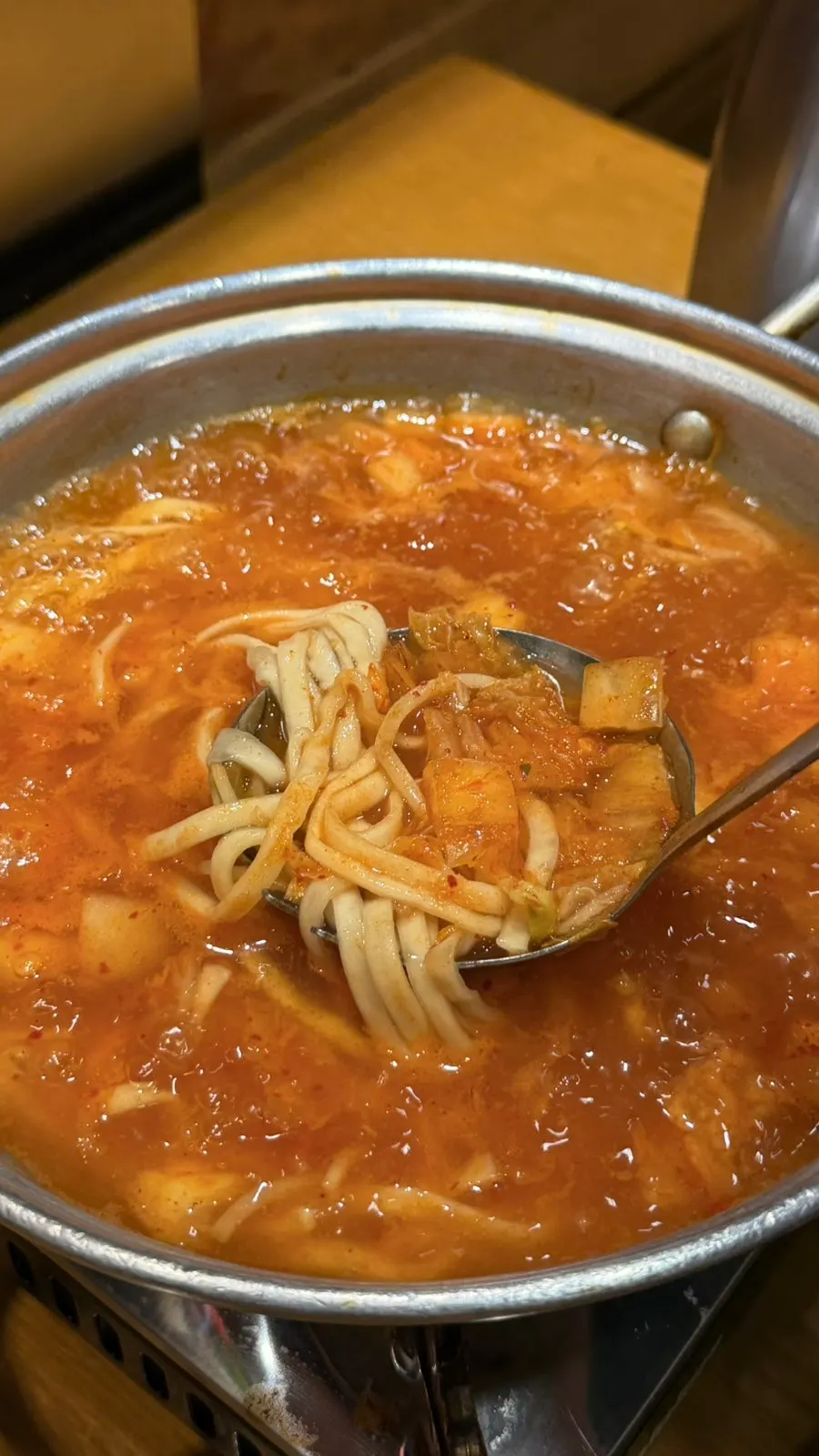 A bowl of kimchi kalguksu with chewy noodles visible