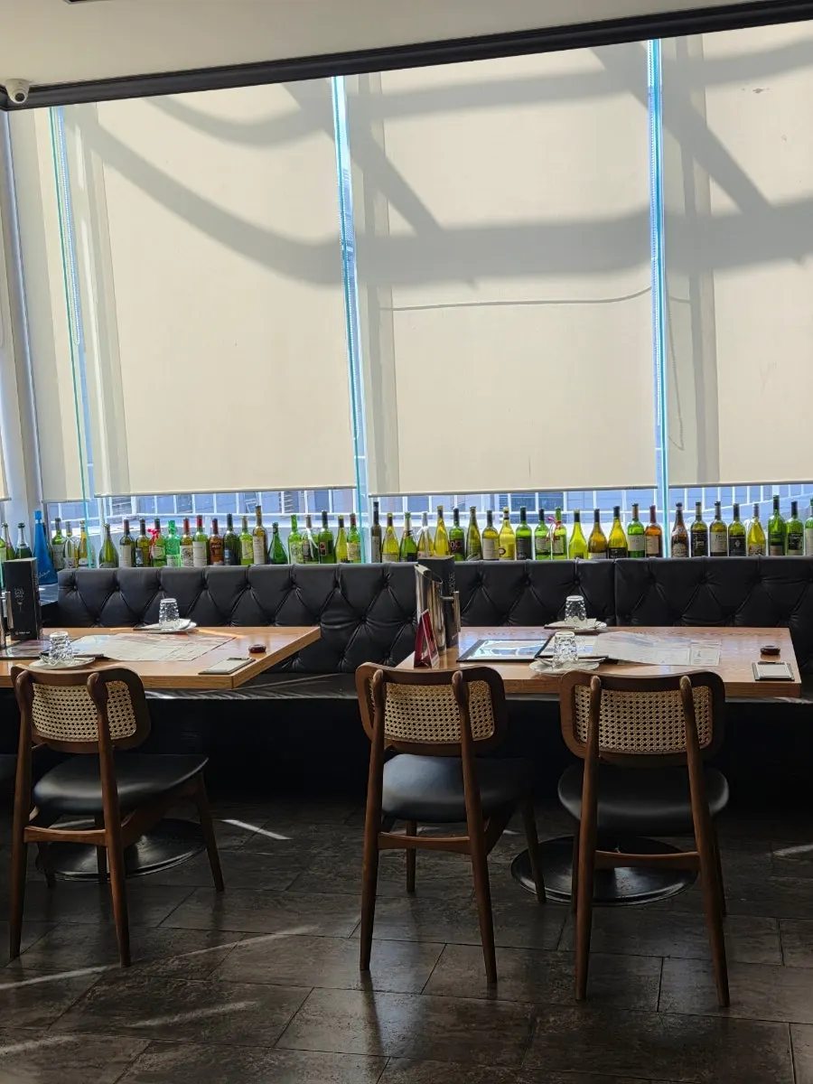Wine bottles by the window under soft lighting