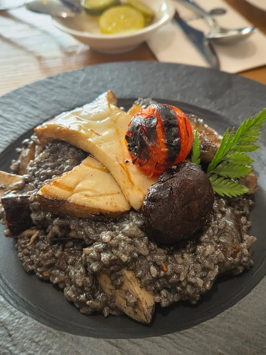 Close-up plating of the black sesame risotto