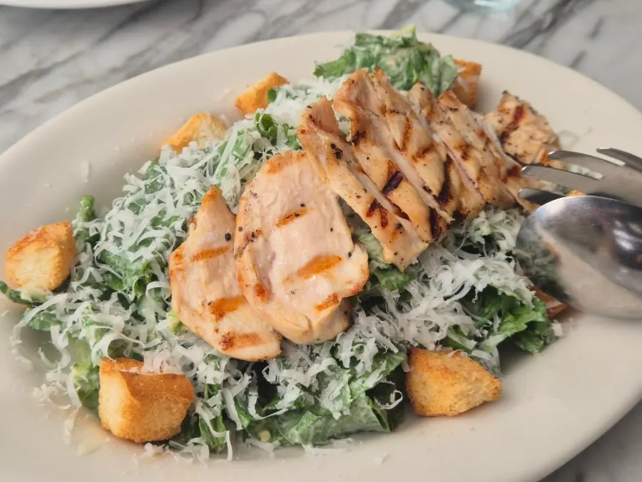 A plate of grilled chicken Caesar salad