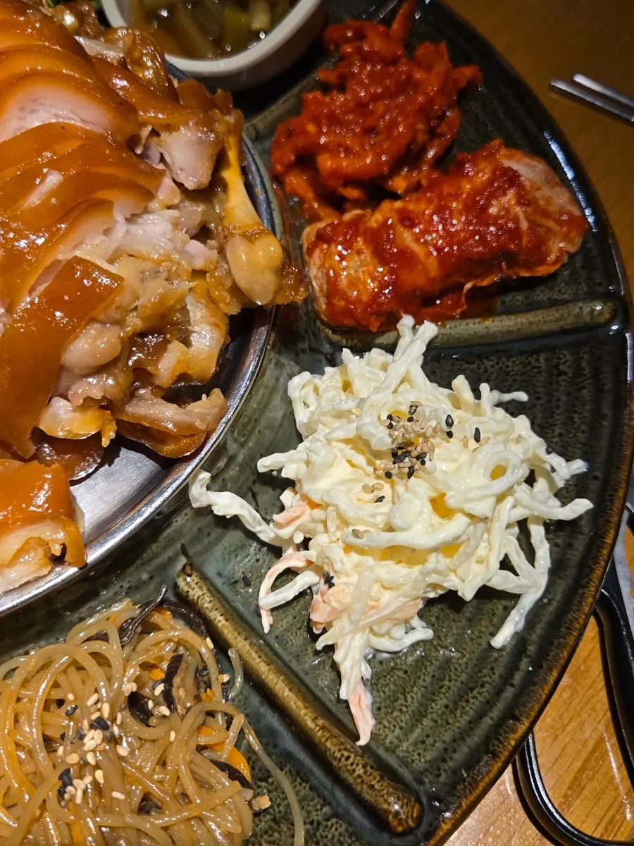 Japchae and kimchi placed at the edge of the plate