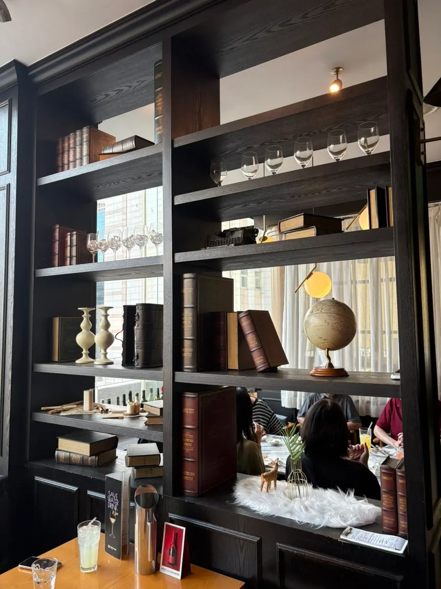 Table beside a display cabinet lined with thick books