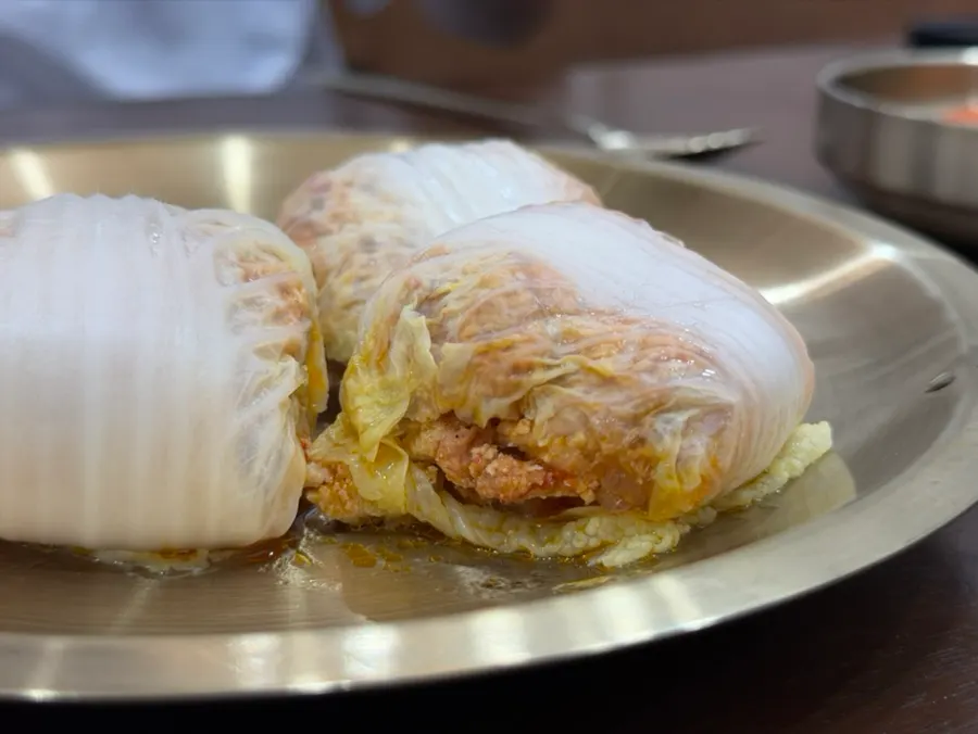 A dumpling combining cabbage leaves and kimchi filling