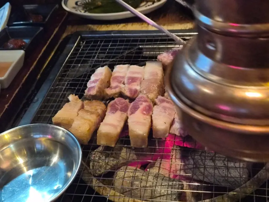 Staff grilling yukgyeopsal on the tabletop grill