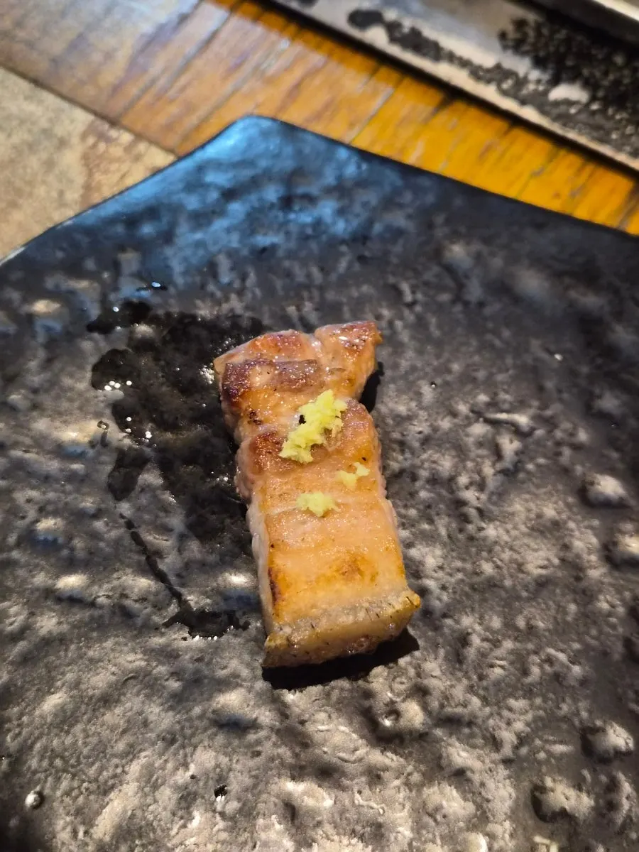 A piece of yukgyeopsal placed on myeong-i namul