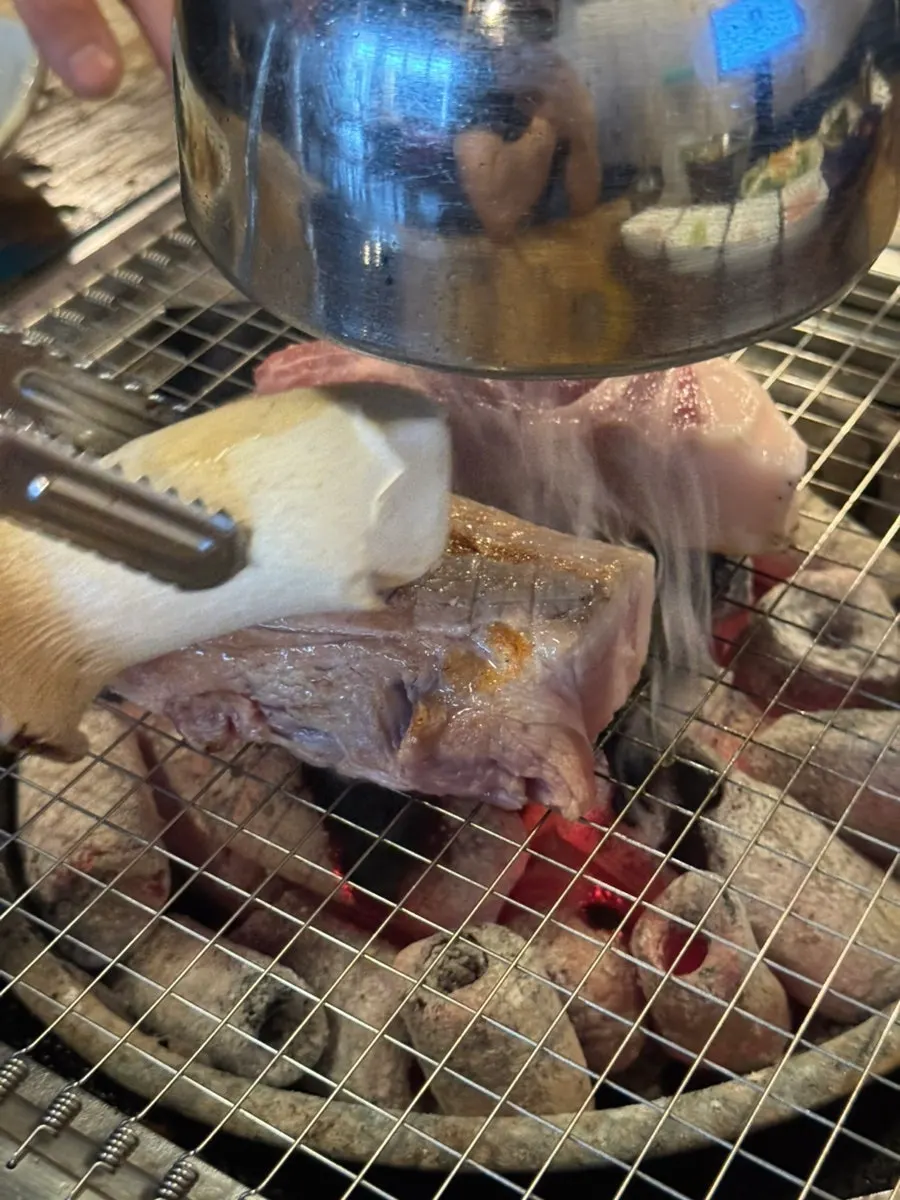 숯불 불판에 올린 두툼한 삼겹살과 목살