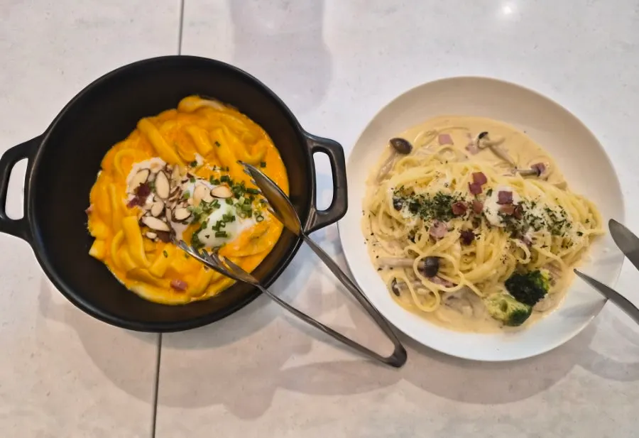 Table spread of pasta and tteokbokki ordered at Seventy Four