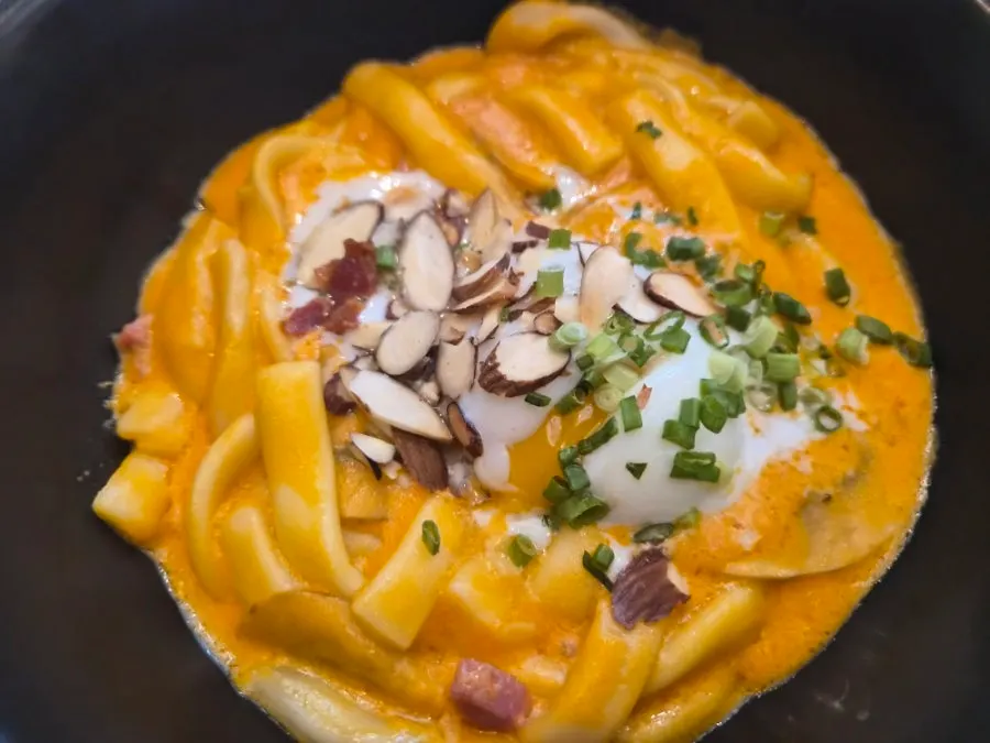 Close-up of the pasta topped with bacon and mushrooms