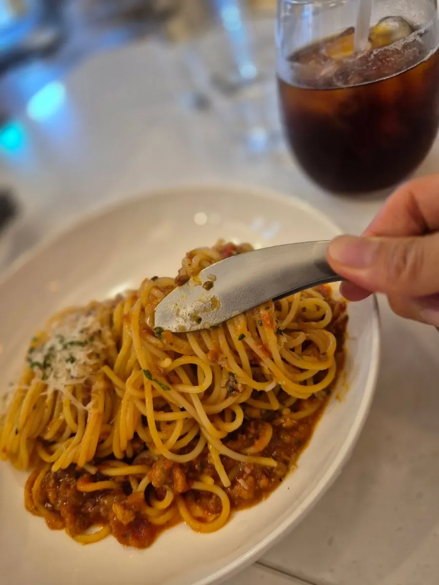 Plate of ragu pasta topped with grated cheese