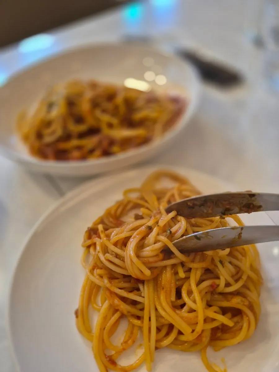 Lunch table alternating between ragu pasta and salad