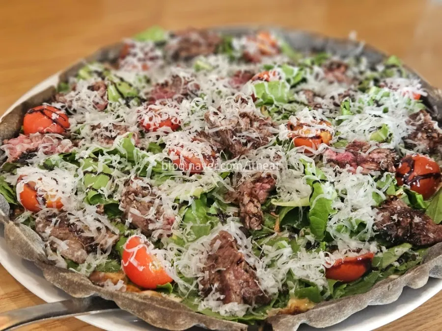 Pizza slice piled high with steak topping