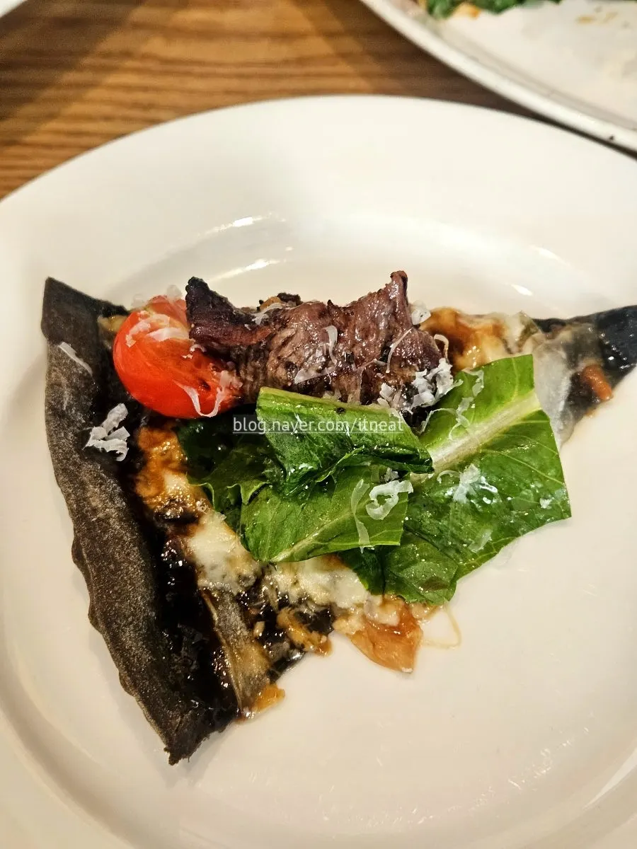 Squid-ink dough pizza dipped in cream sauce