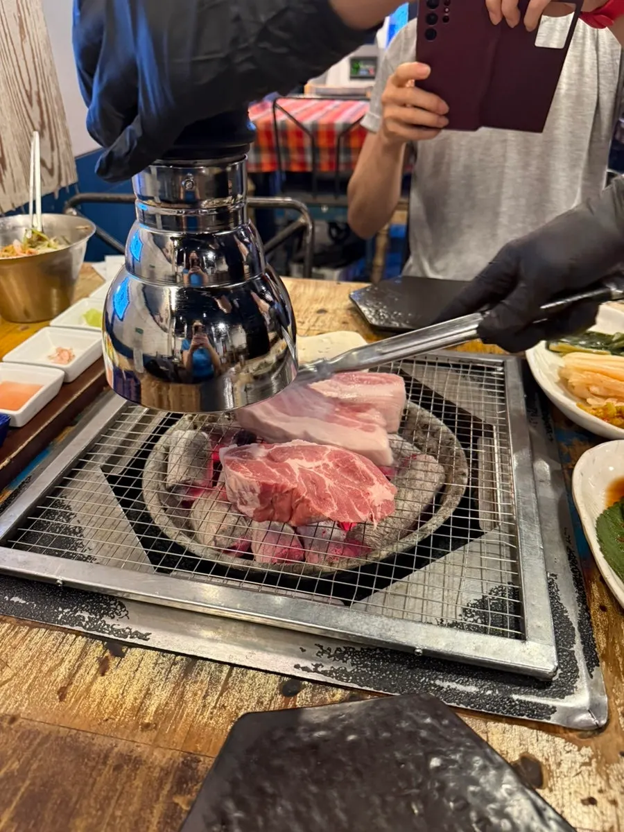 Thick cuts of ogyeopsal placed over the charcoal