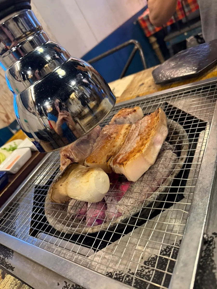 Staff member flipping the meat on the grill