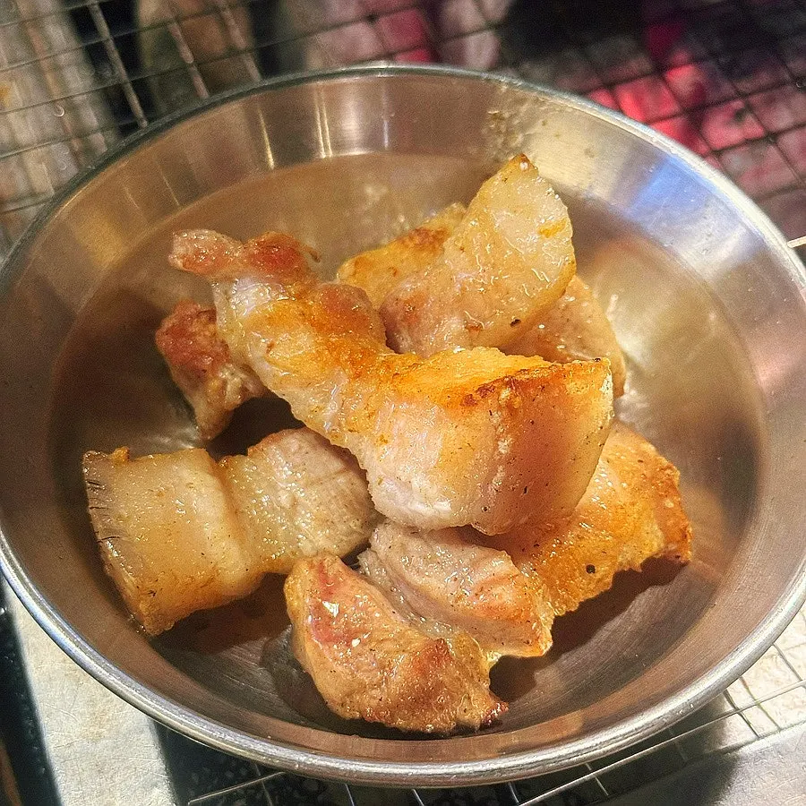 직원이 숯불에서 오겹살을 구워주는 모습