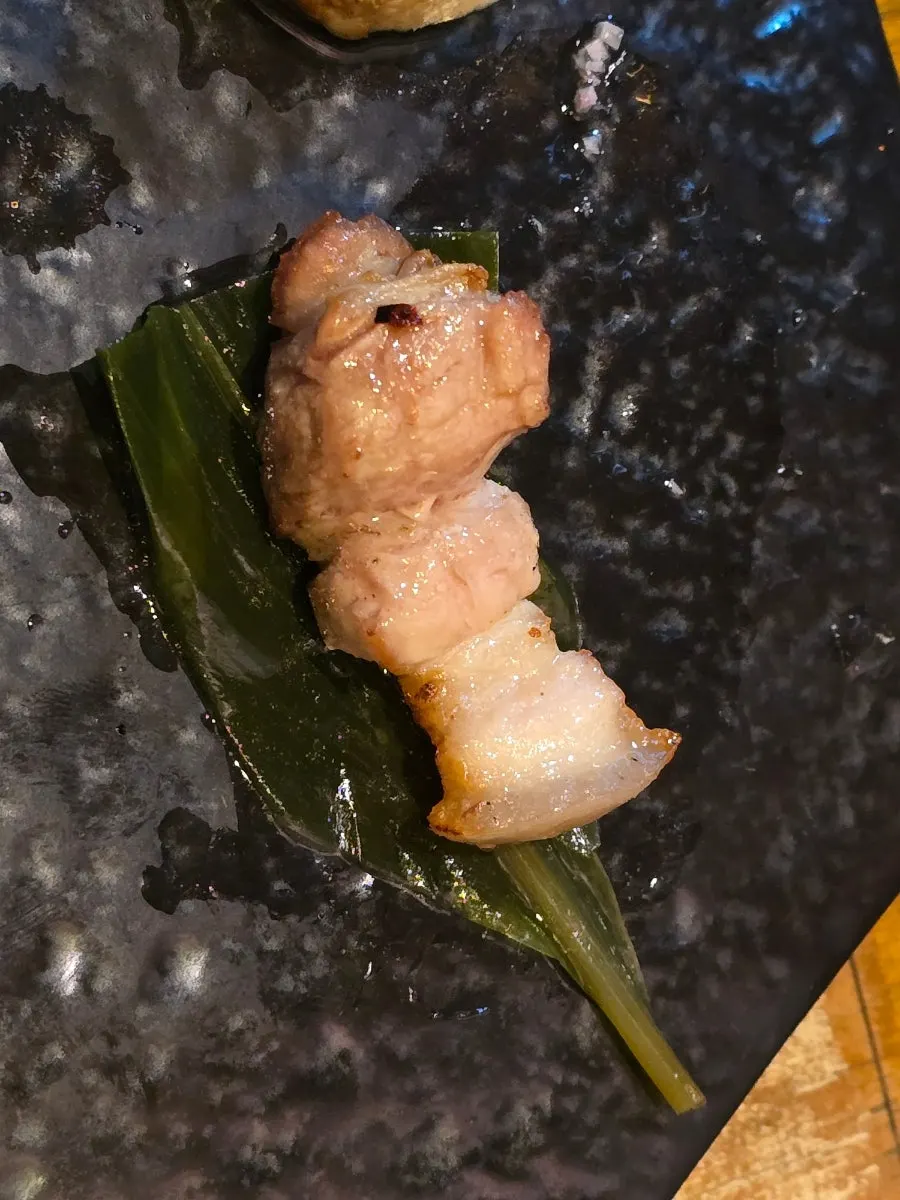 구운 흑돼지 오겹살 한 점 들어 올린 모습