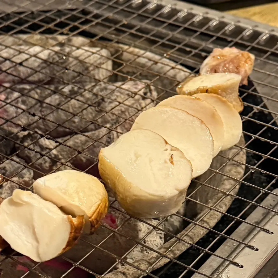 Yukgyeopsal and mushrooms grilling over charcoal