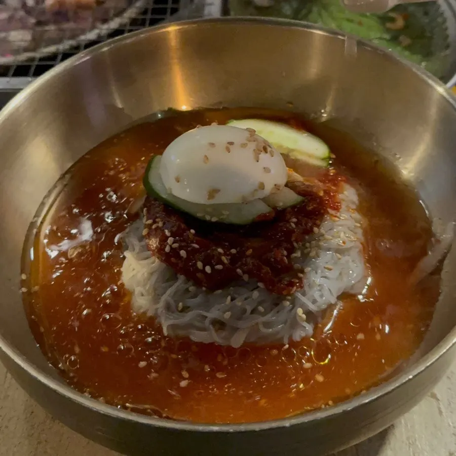 A bowl of bibim naengmyeon with a sesame oil aroma