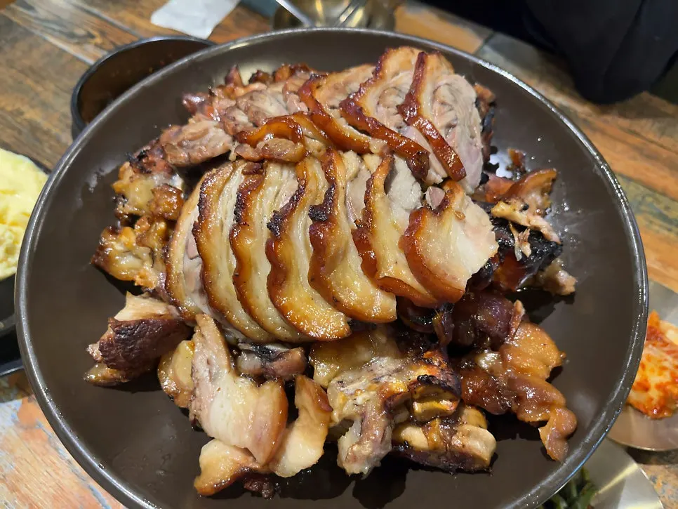 A piece of wood-fired jokbal placed on a lettuce leaf