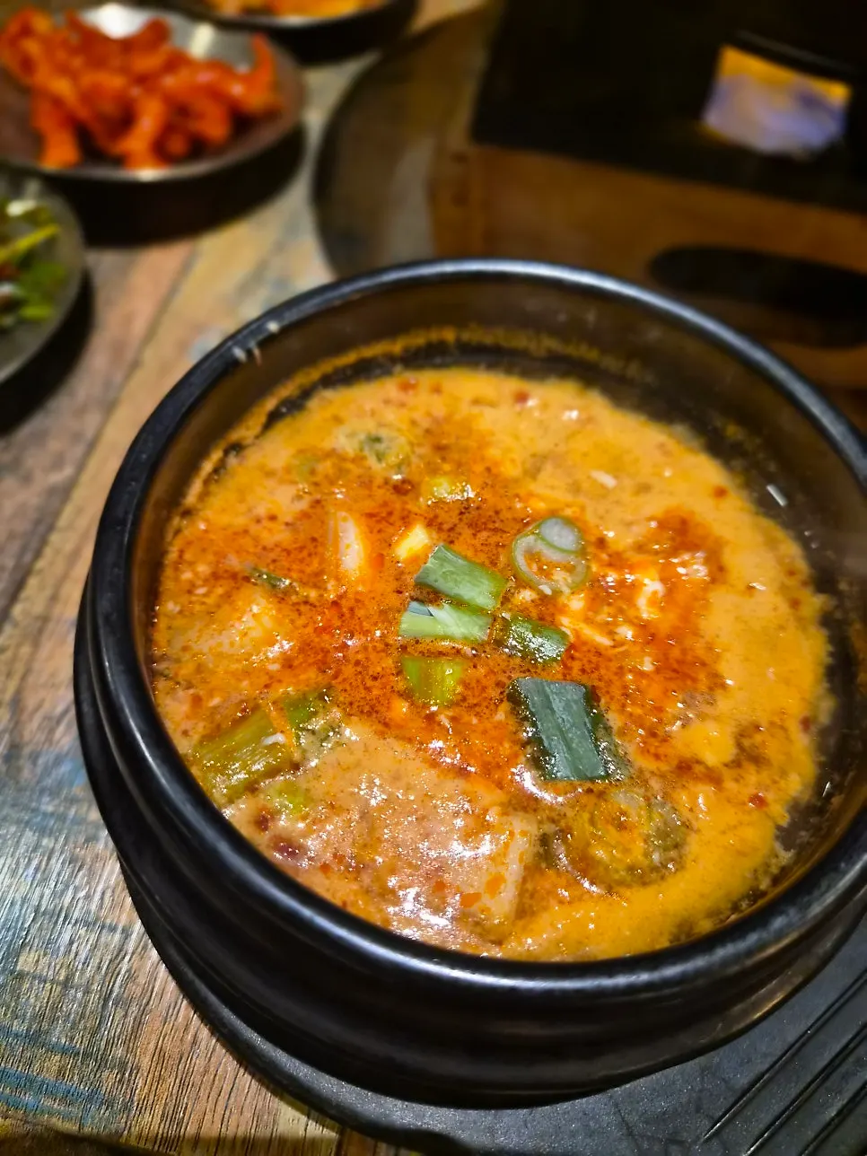 Full dinner spread with bossam, makguksu, pizza, and sundubu jjigae