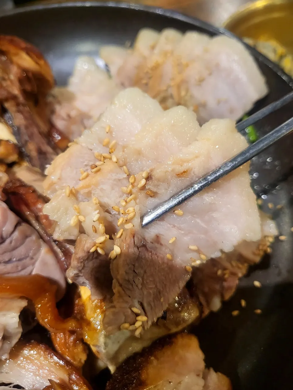 Wood-fired jokbal picked up with chopsticks