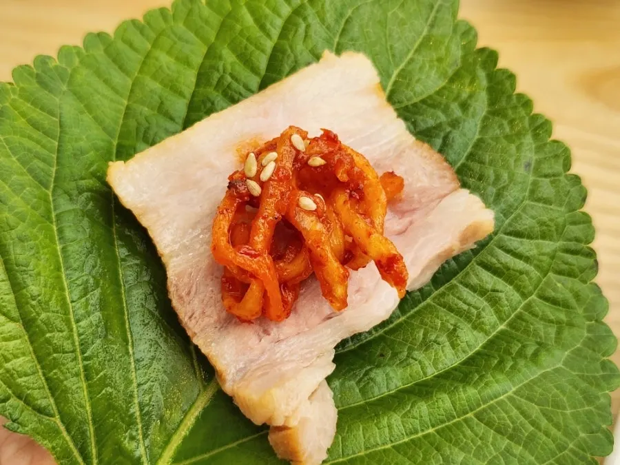 Crisp kimchi plated alongside bossam