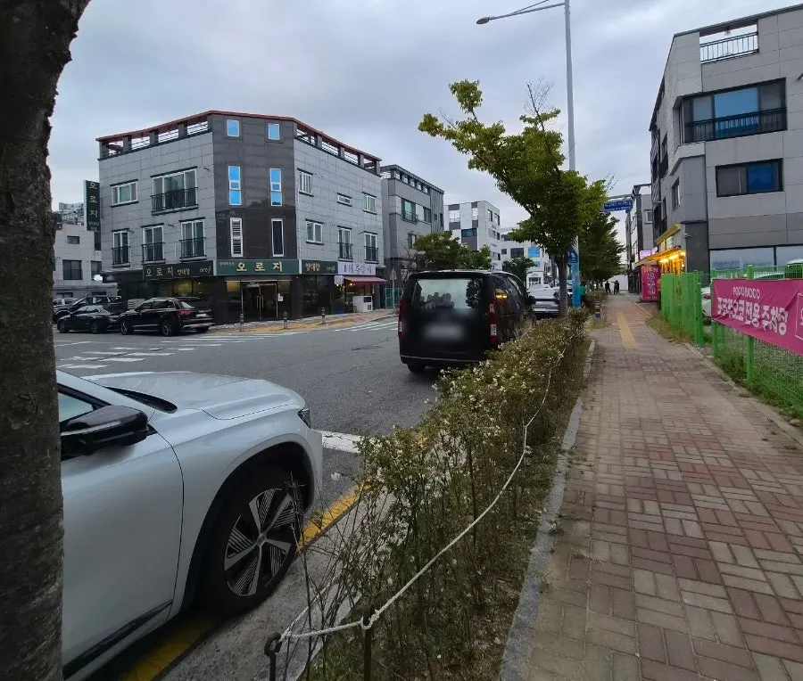 Roadside and nearby vacant lot parking in front of the shop
