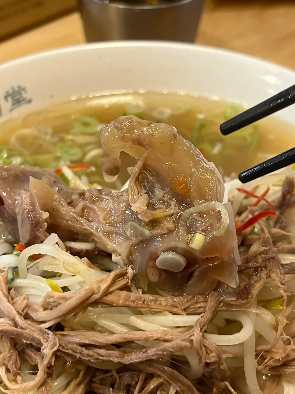 젓가락으로 들어올린 힘줄과 쌀국수 면