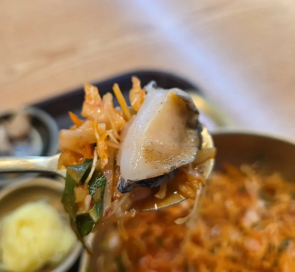 A bite of mulhoe with sashimi layered by type