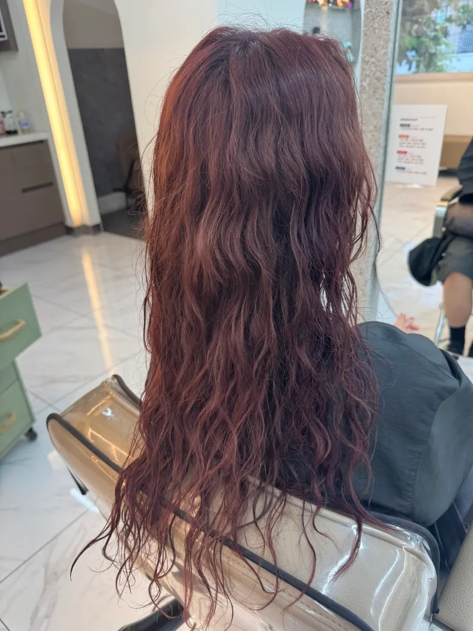 Long wavy hair in a soft purple-red shade