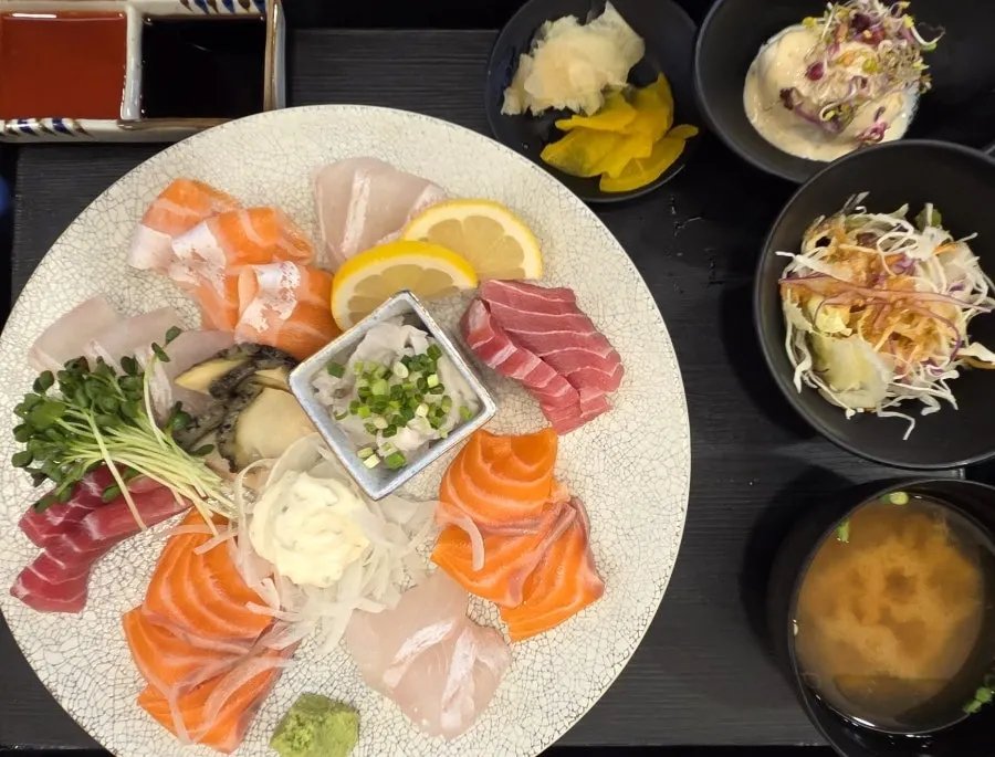 Table set with sashimi platter, ramen and shrimp tempura