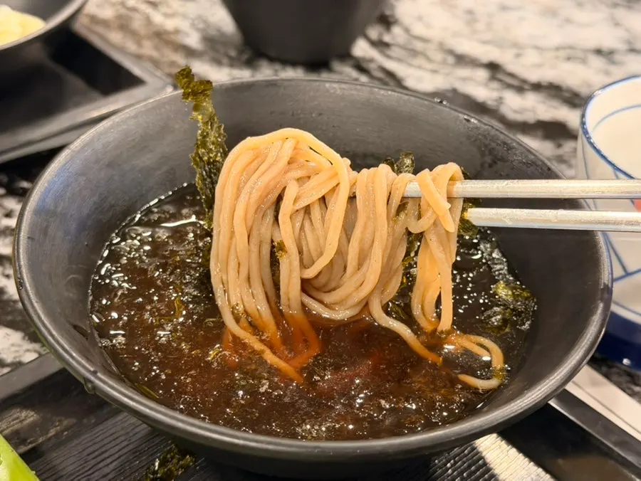 Dipping soba noodles into the broth