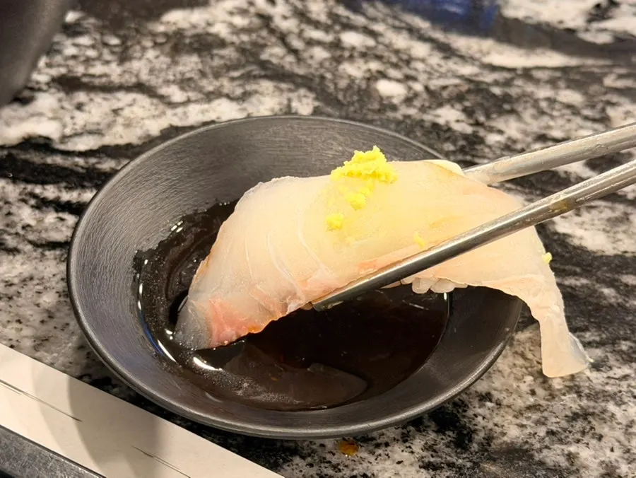 Close-up of sushi topped with a generous cut of raw fish
